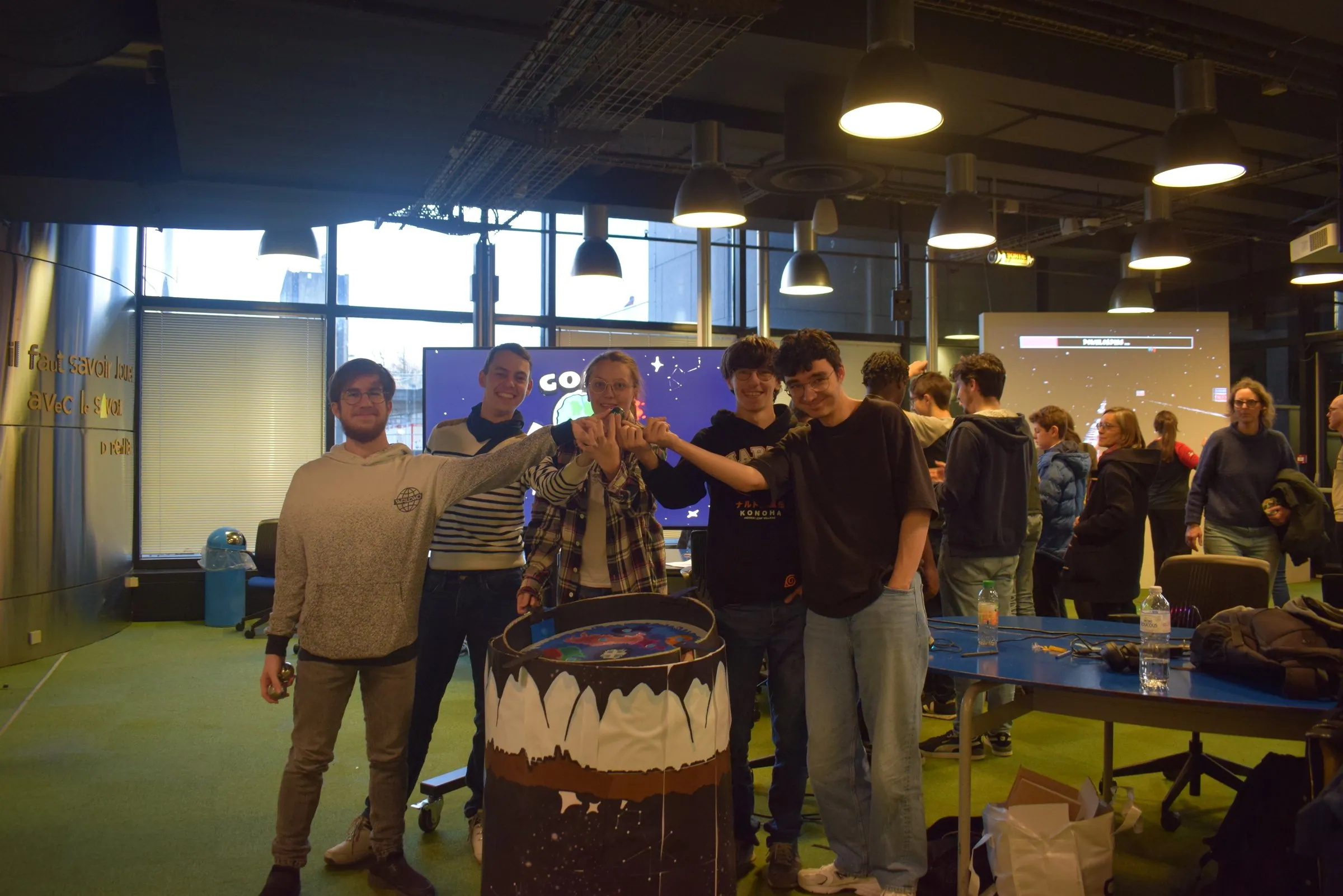 The team posing next to the table in the jam space.